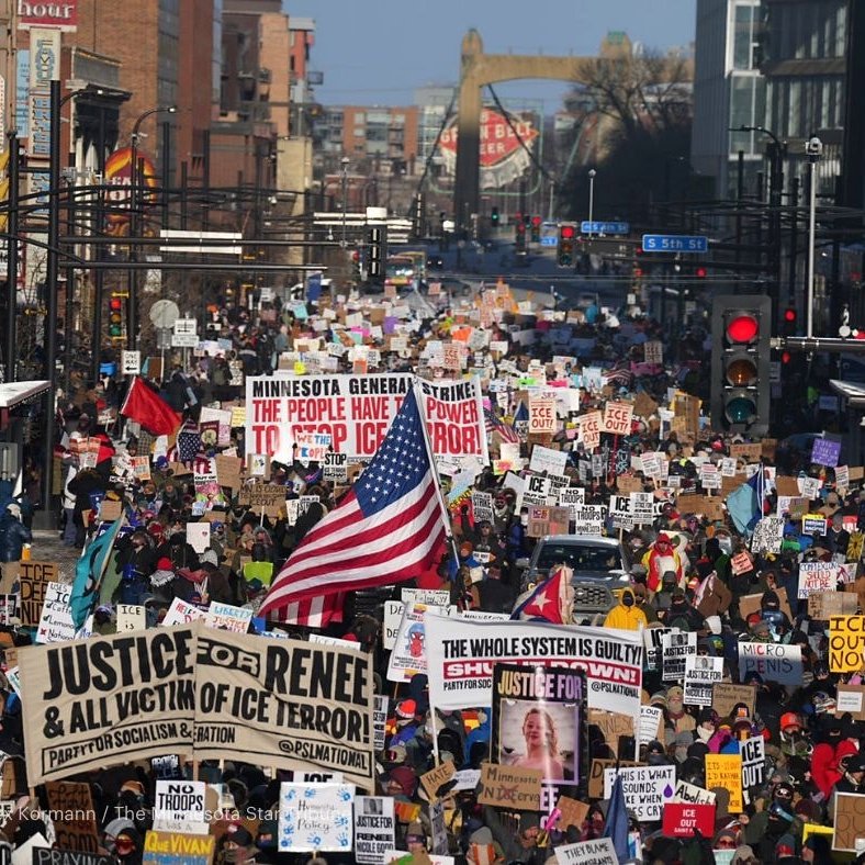 Photo of downtown Minneapolis street filled with protesters carrying signs against Trump and ICE.